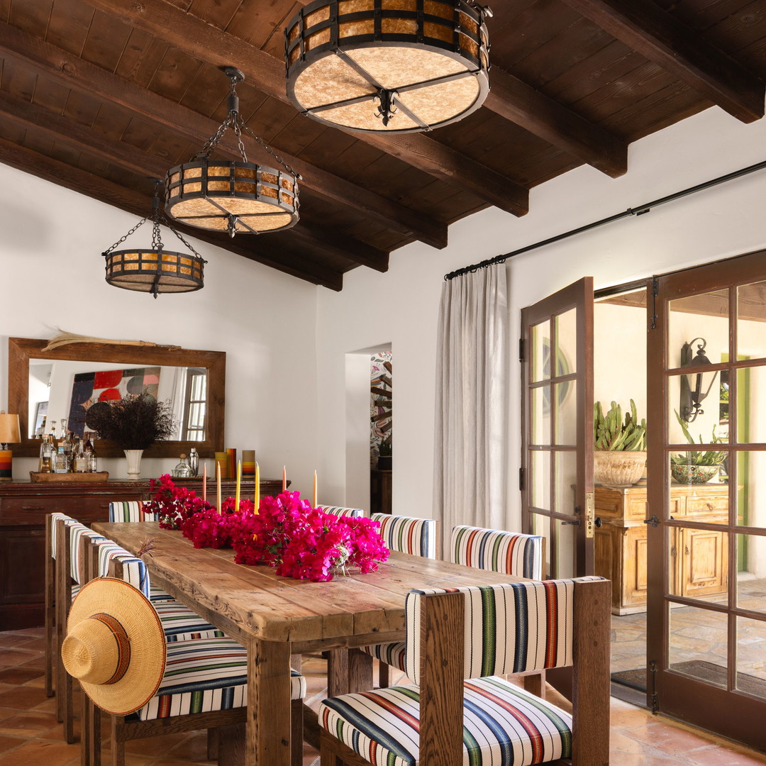 a dining room with a wooden table and colorful chairs