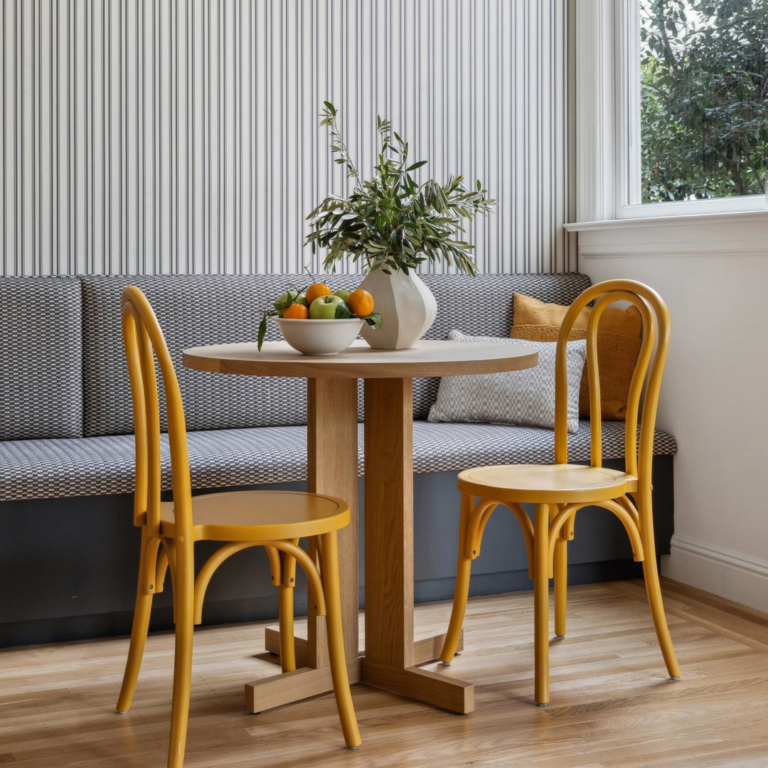 a table with two chairs and a bowl of fruit on it