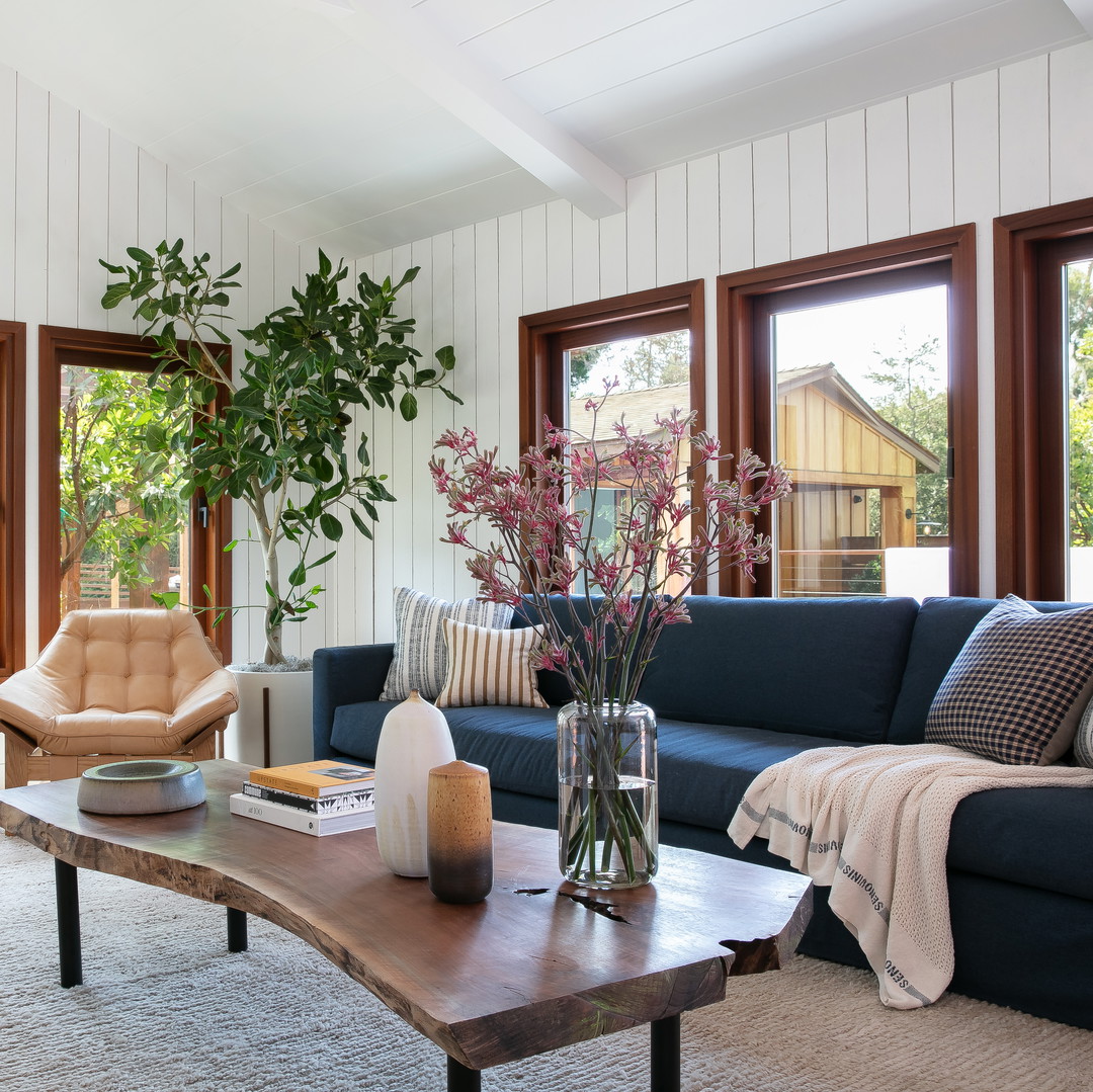 a living room filled with furniture and lots of windows