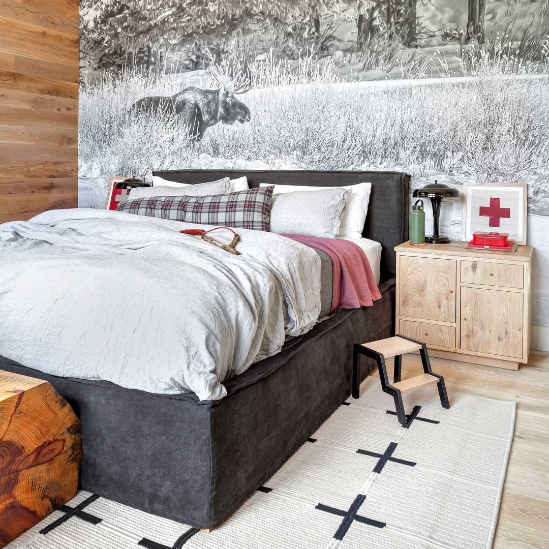 a bedroom with a large bed and a mountain mural on the wall