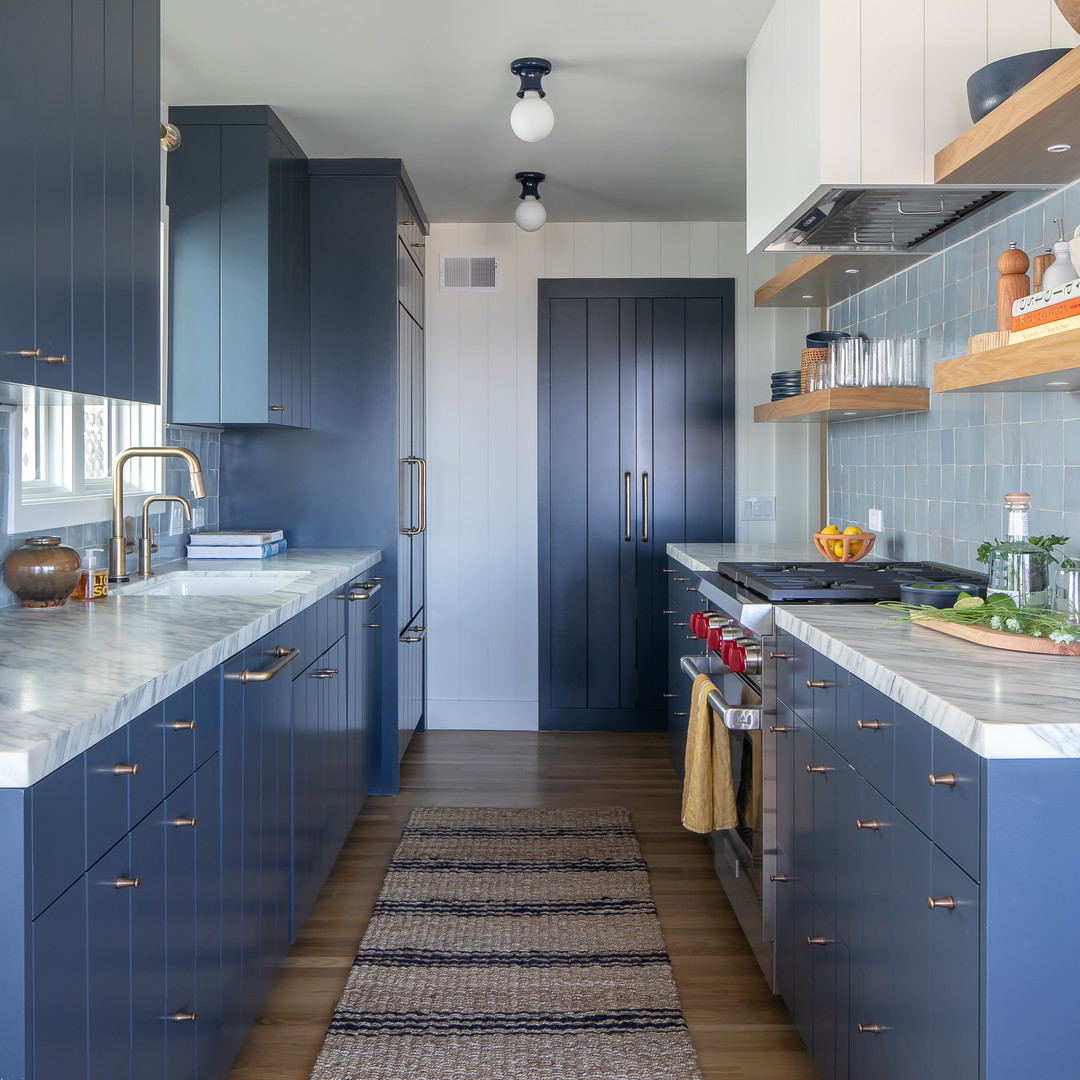 a kitchen with blue cabinets and a rug on the floor