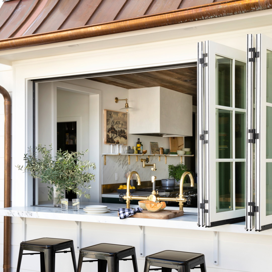 a kitchen with three stools in front of it