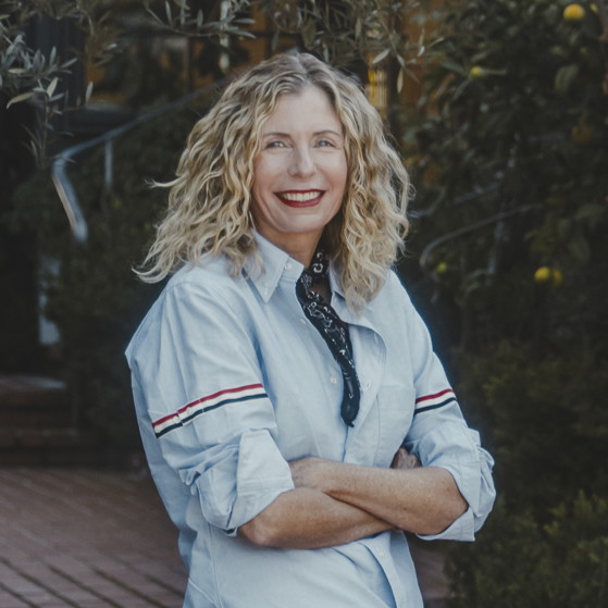 a woman standing on a brick walkway with her arms crossed