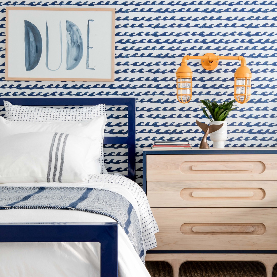 a bedroom with a blue and white wallpaper and a bed