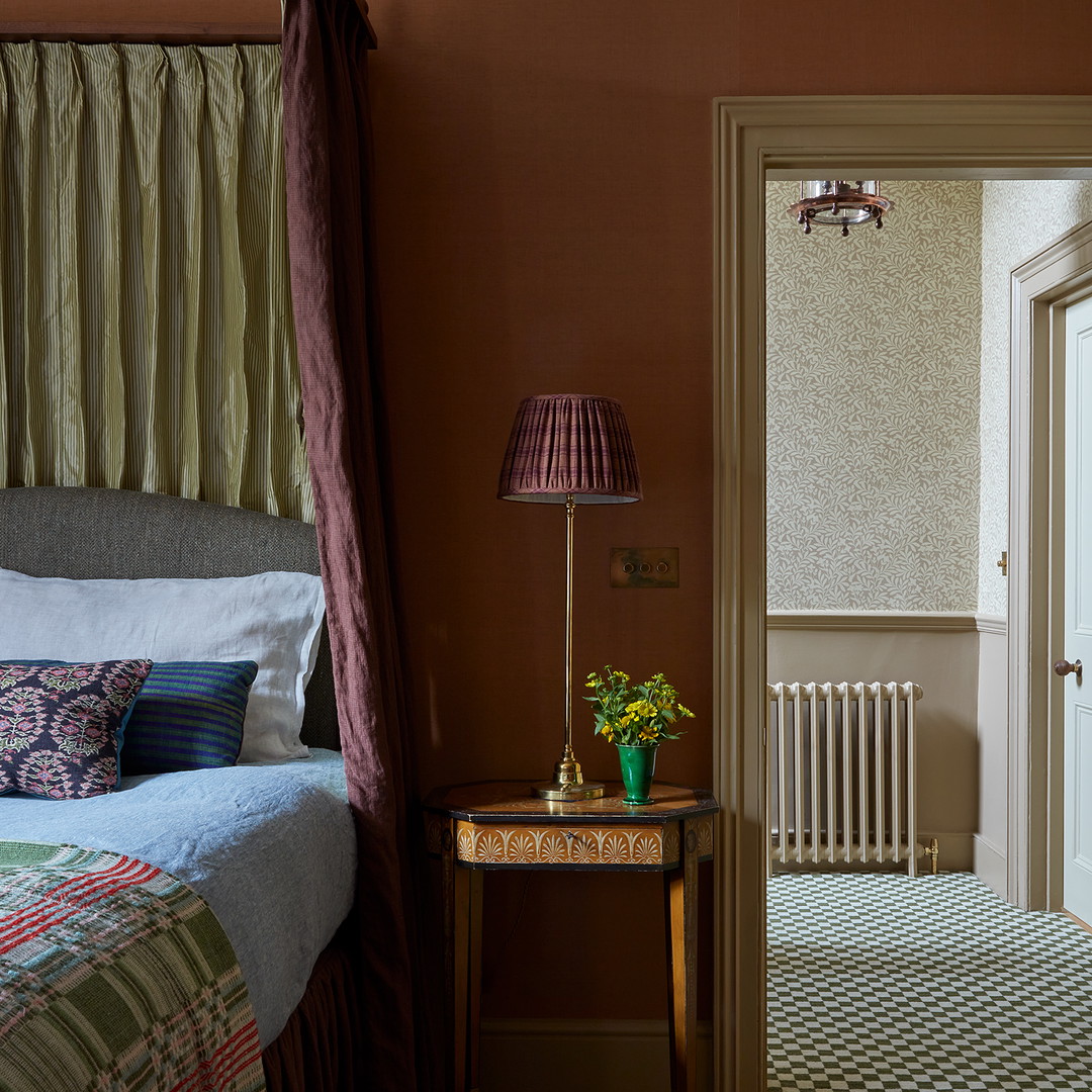 a bed room with a neatly made bed and a lamp