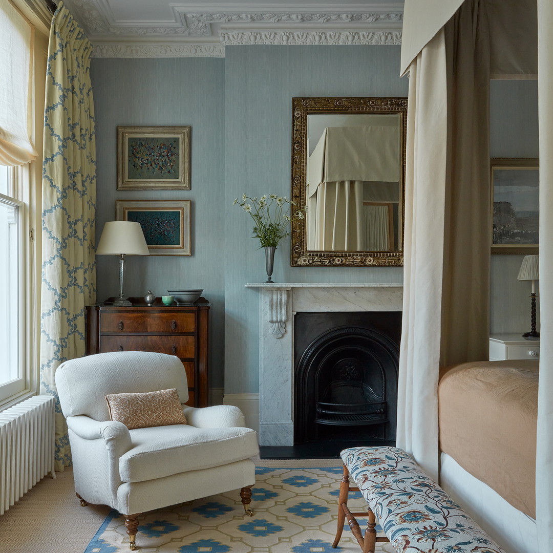 a bedroom with a bed, a chair and a fireplace