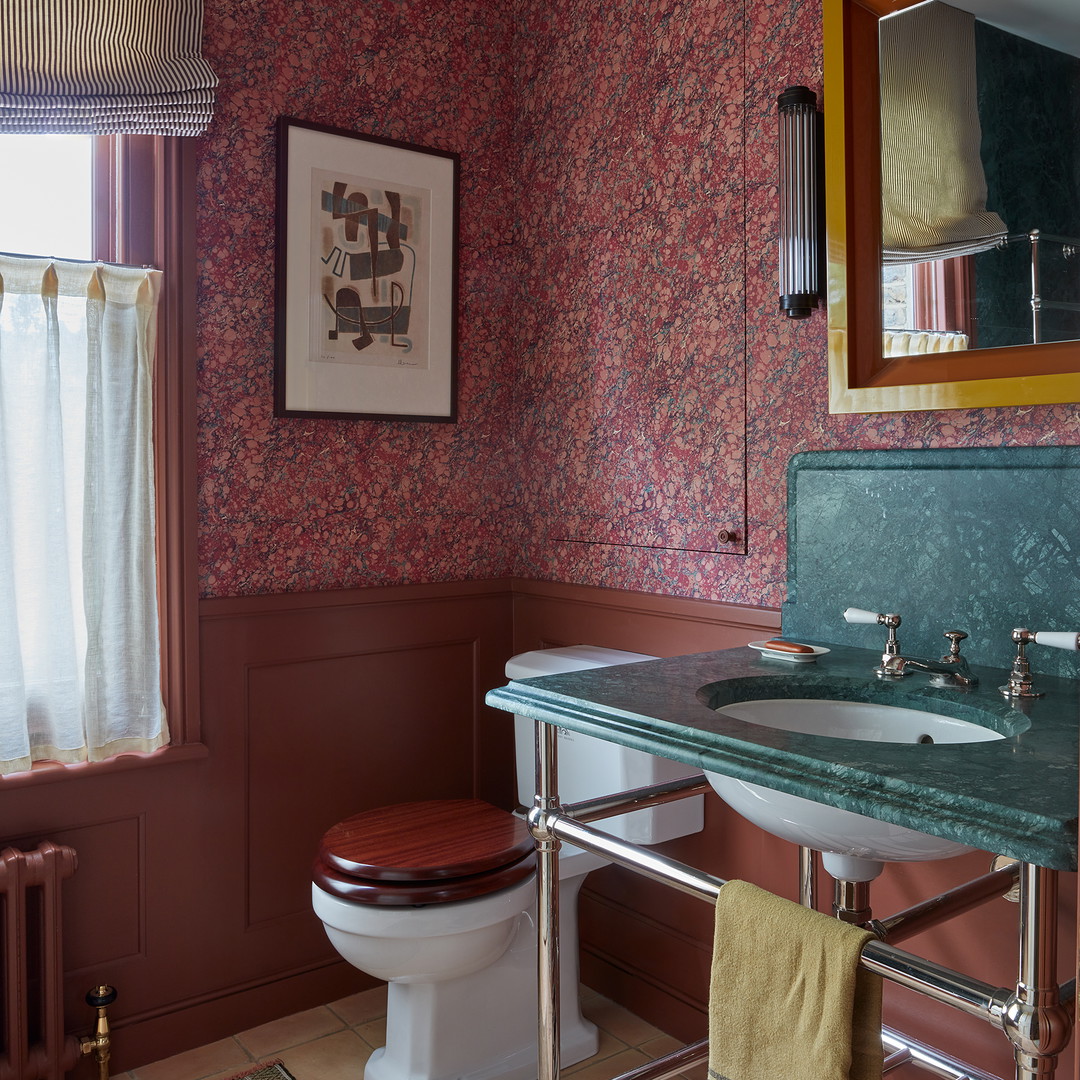 a bathroom with a toilet, sink, and mirror