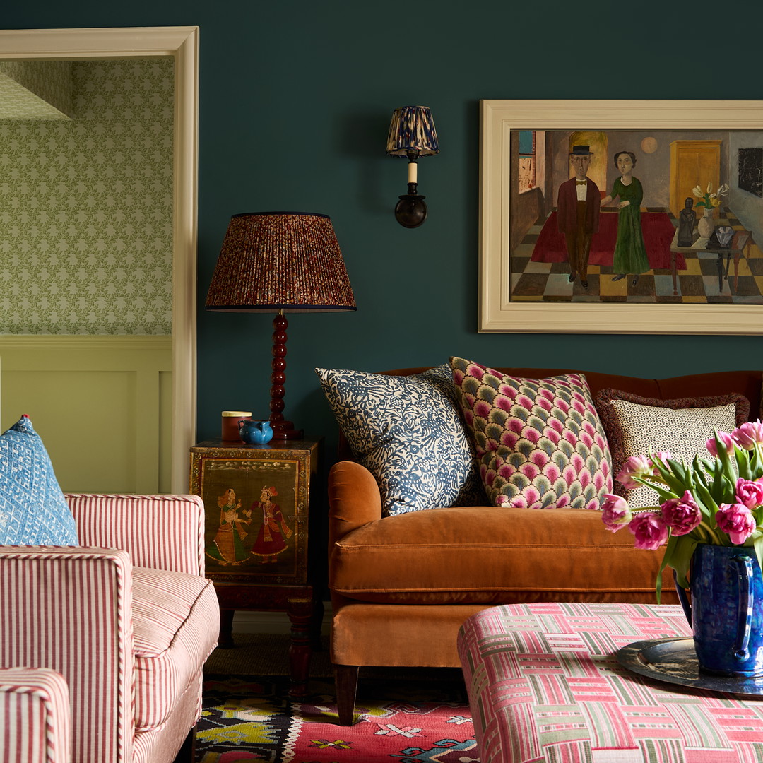 a living room filled with furniture and a painting on the wall