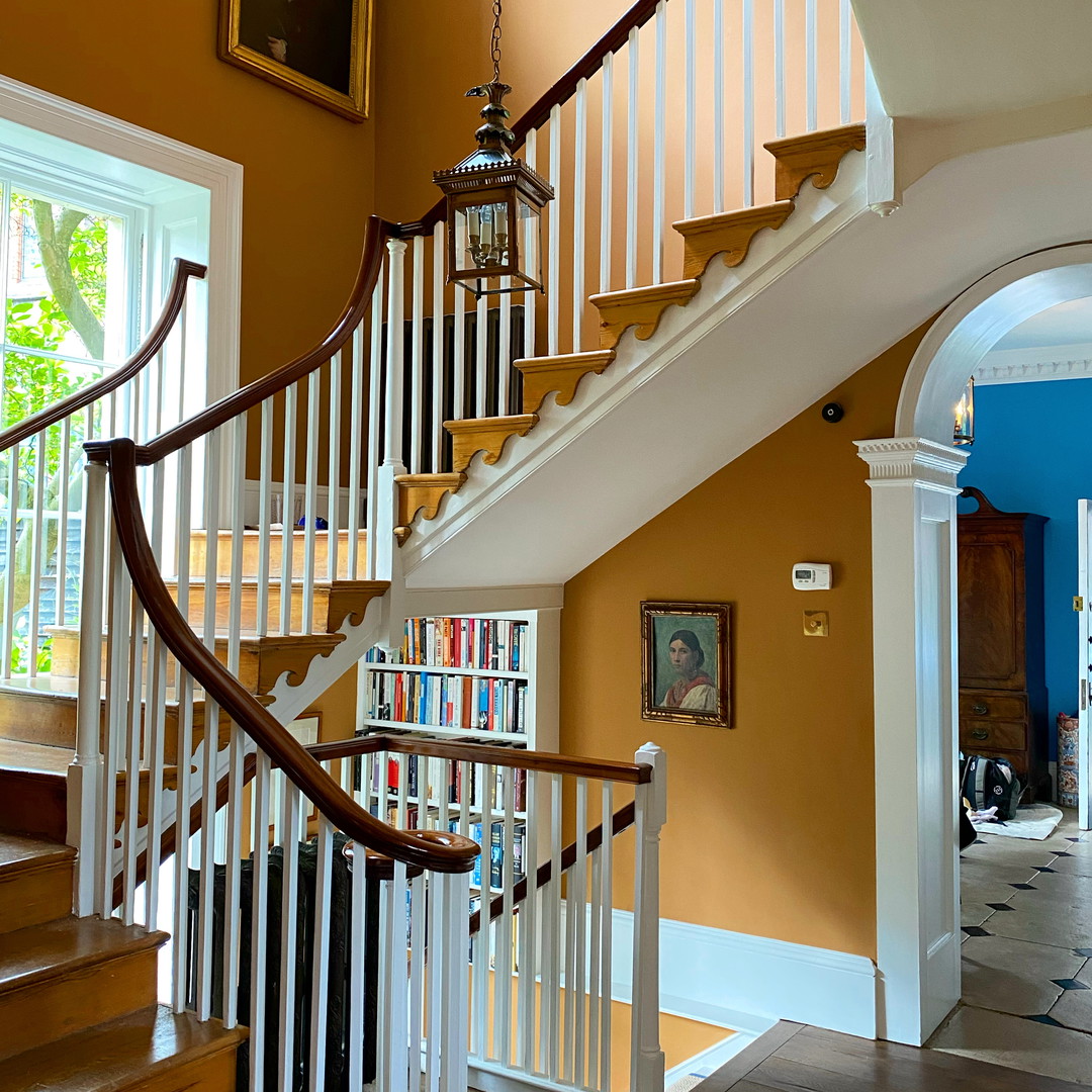 a staircase leading to a living room with a book shelf