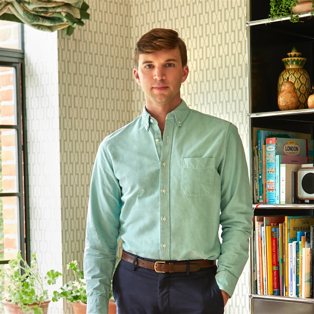 a man standing in front of a book shelf