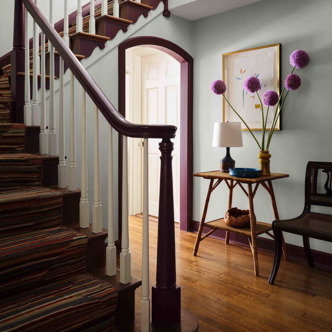 a room with a staircase and a table with flowers on it