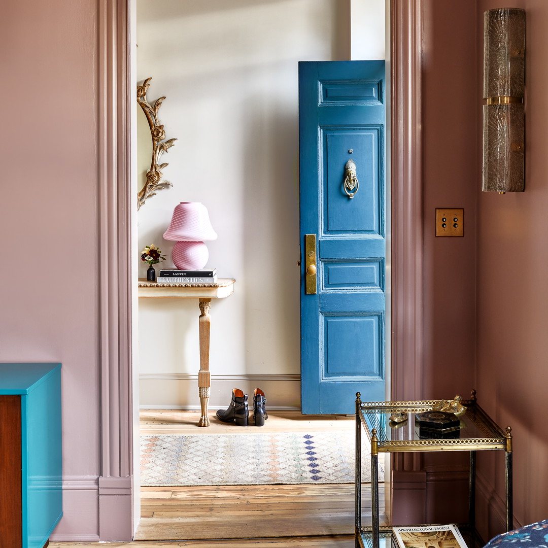 a living room with a blue door and pink walls