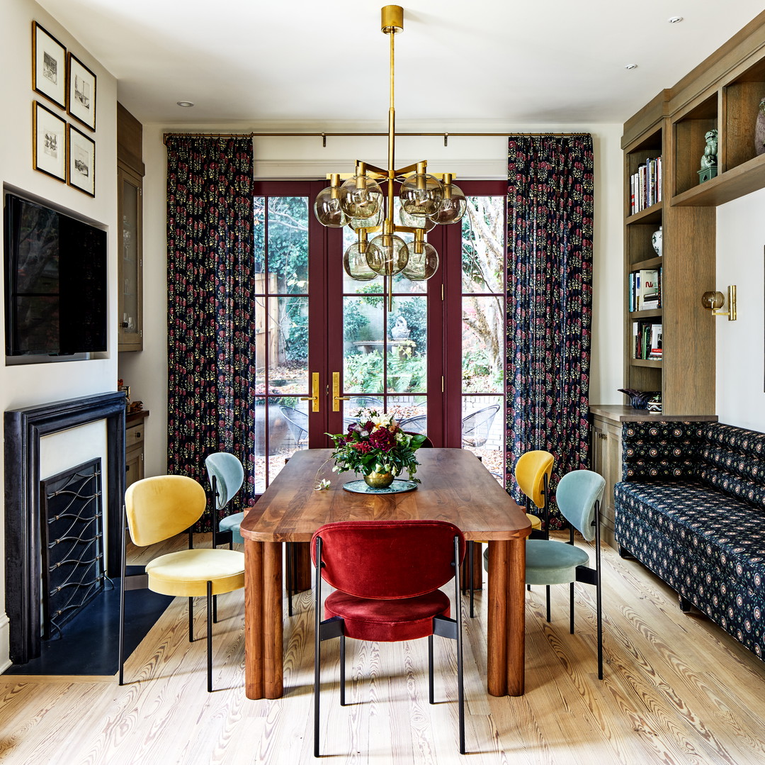 a room with a table, chairs, a couch and a fireplace