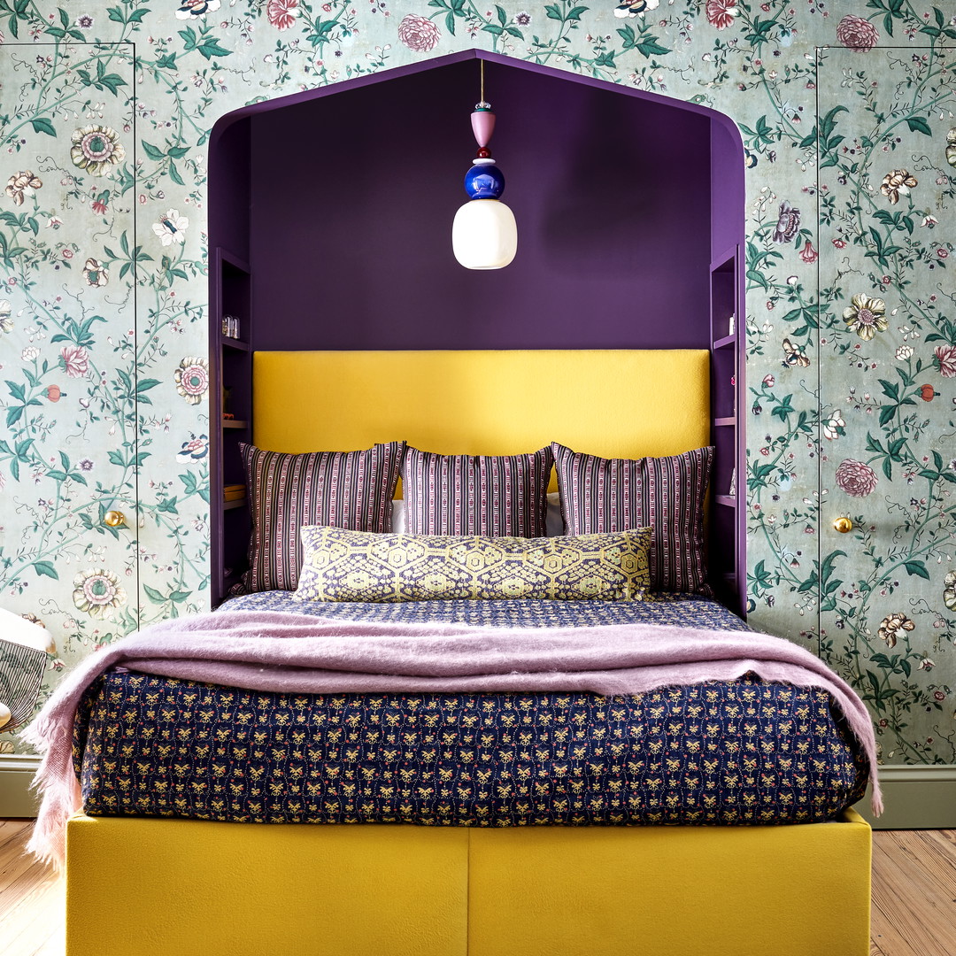 a bedroom with a purple and yellow headboard