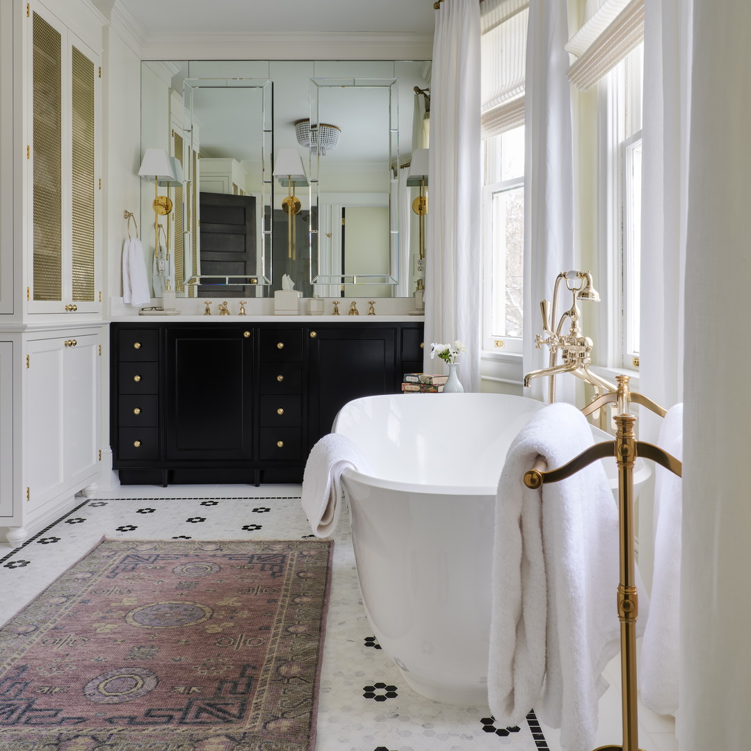 a bathroom with a large tub and a rug on the floor