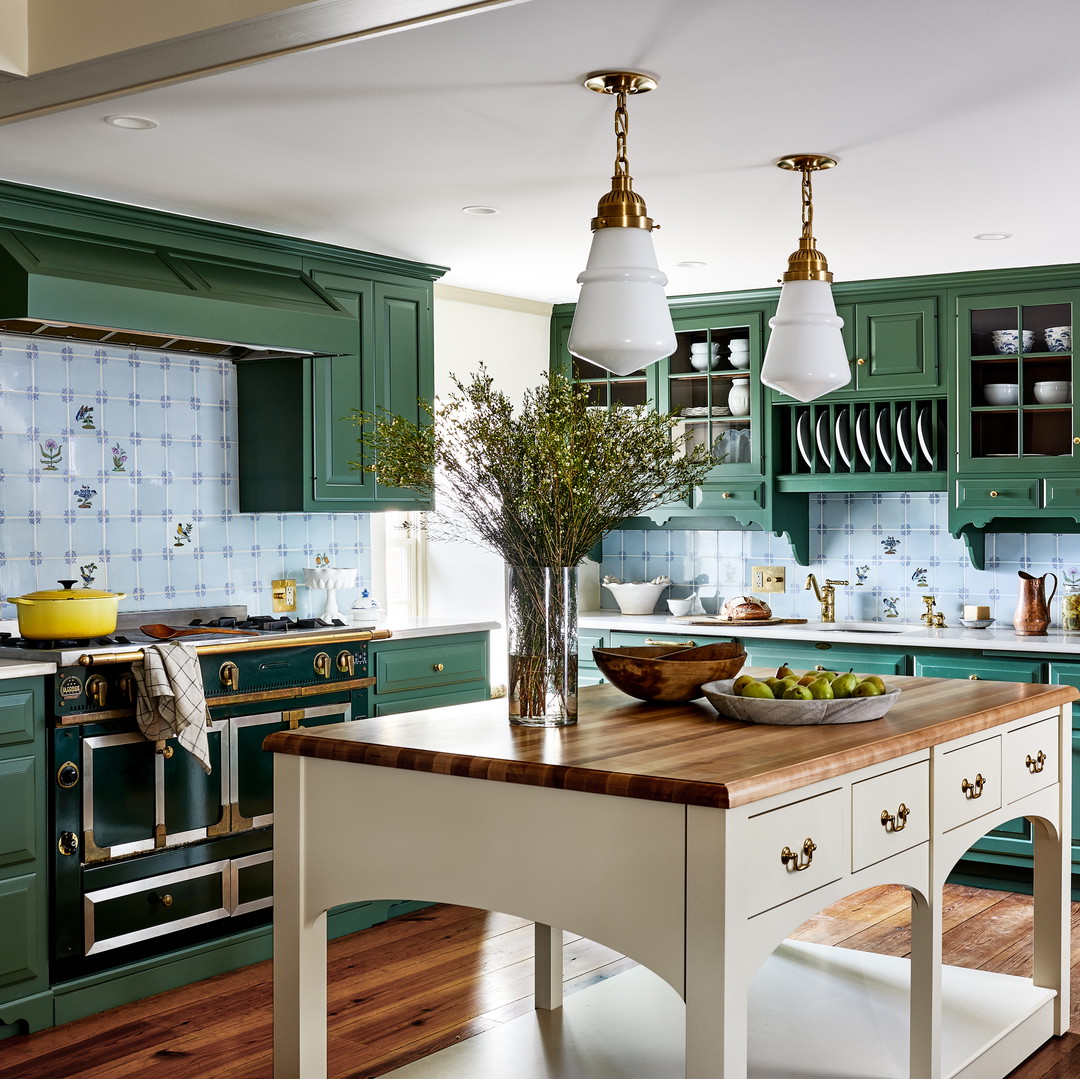 a kitchen with green cabinets and wooden floors