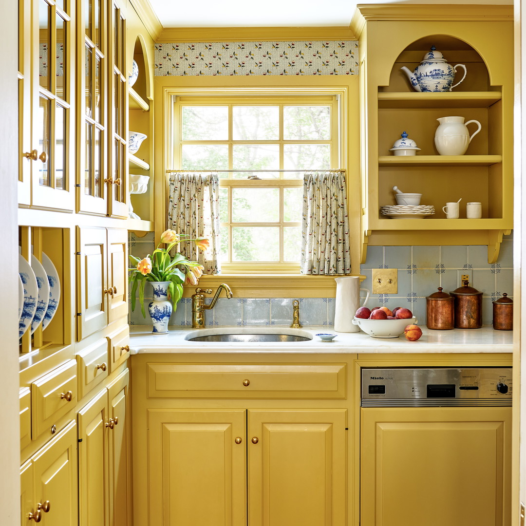 a kitchen with yellow cabinets and a window