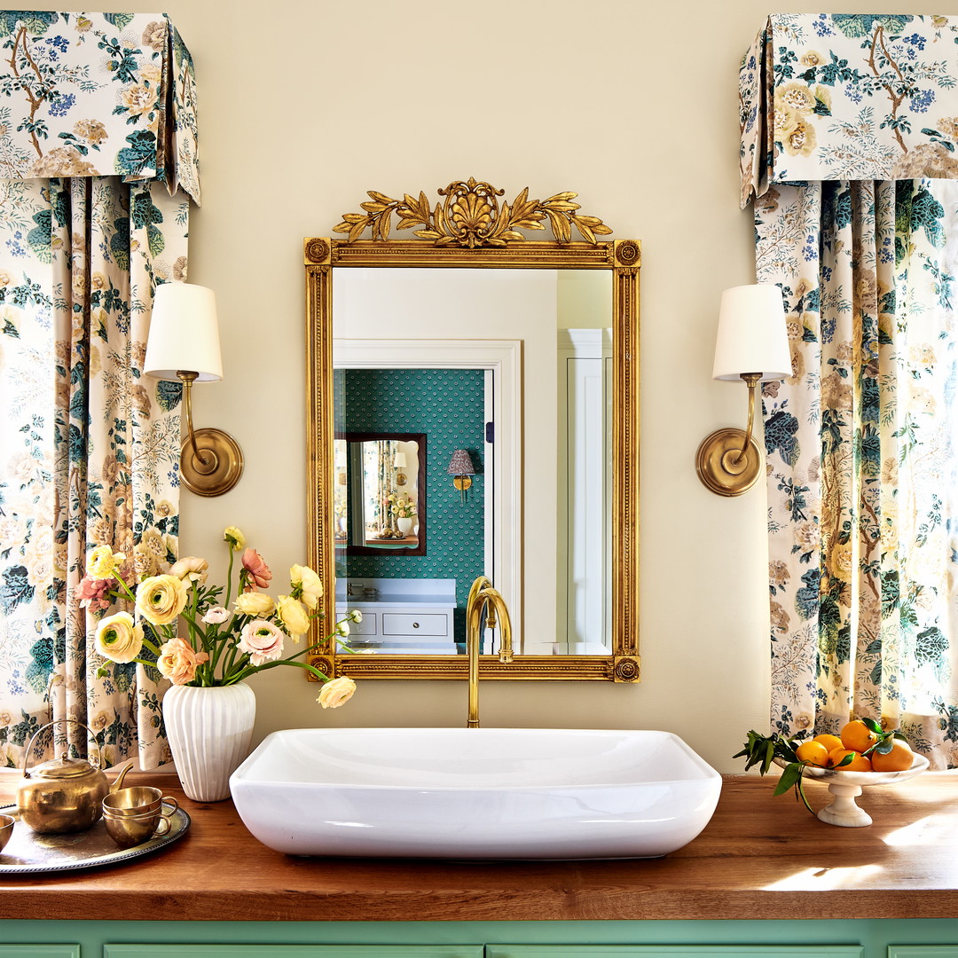 a bathroom sink sitting under a mirror next to a window