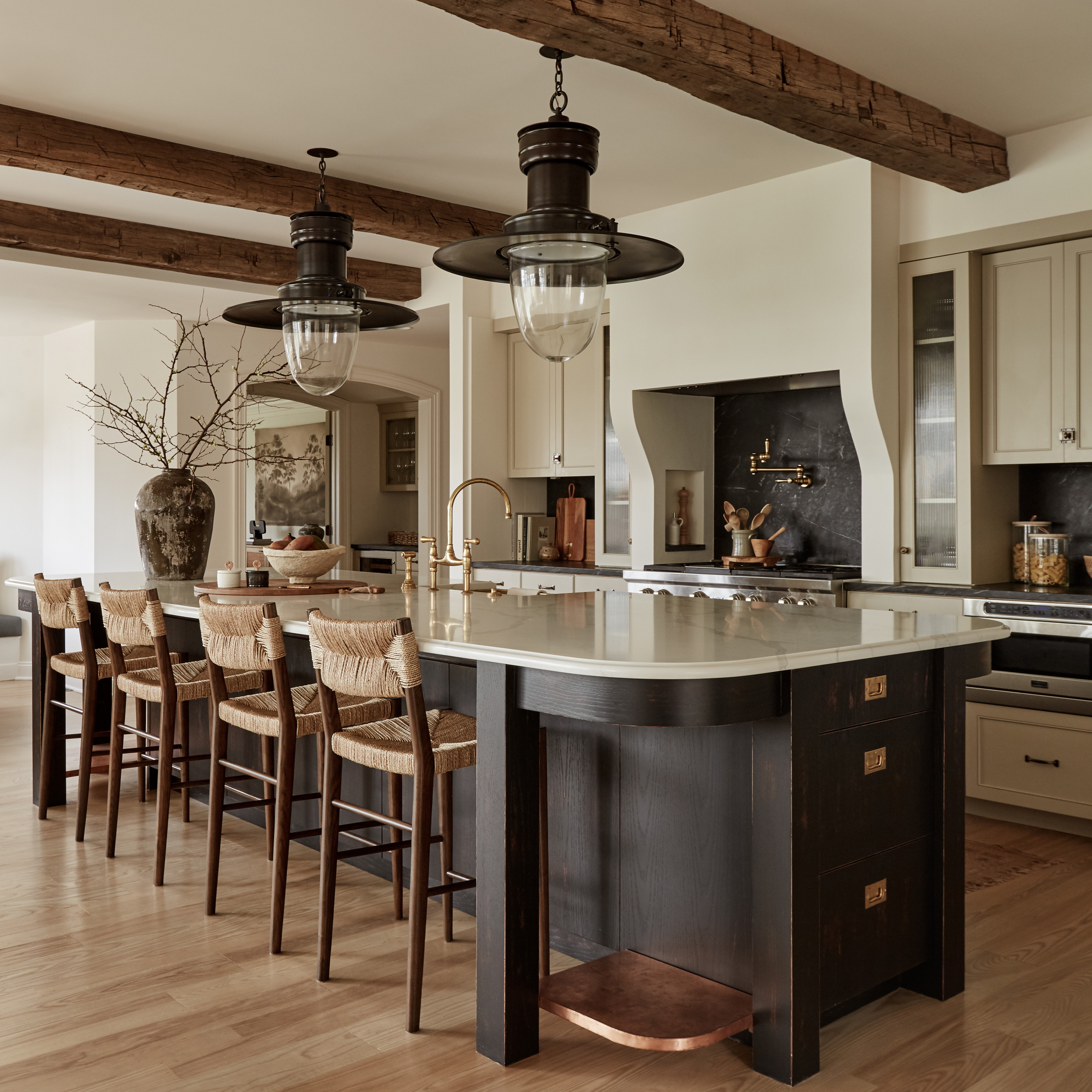 a large kitchen with a center island surrounded by chairs