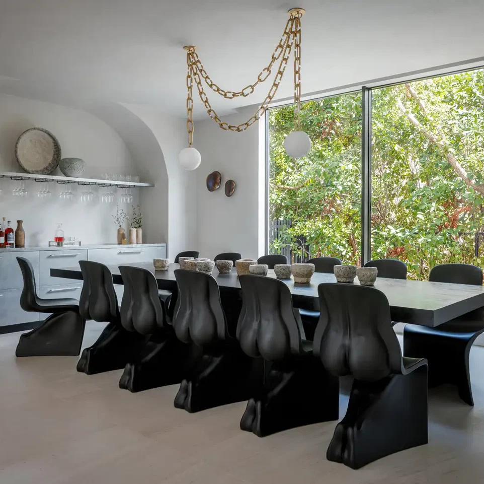 a dining room with a large table and black chairs