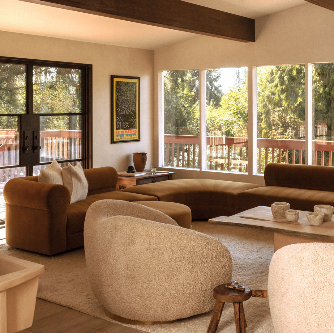 a living room filled with furniture and large windows