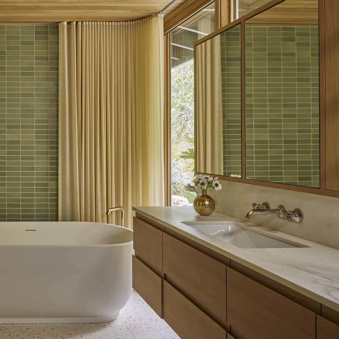 a bathroom with a tub, sink, and mirror