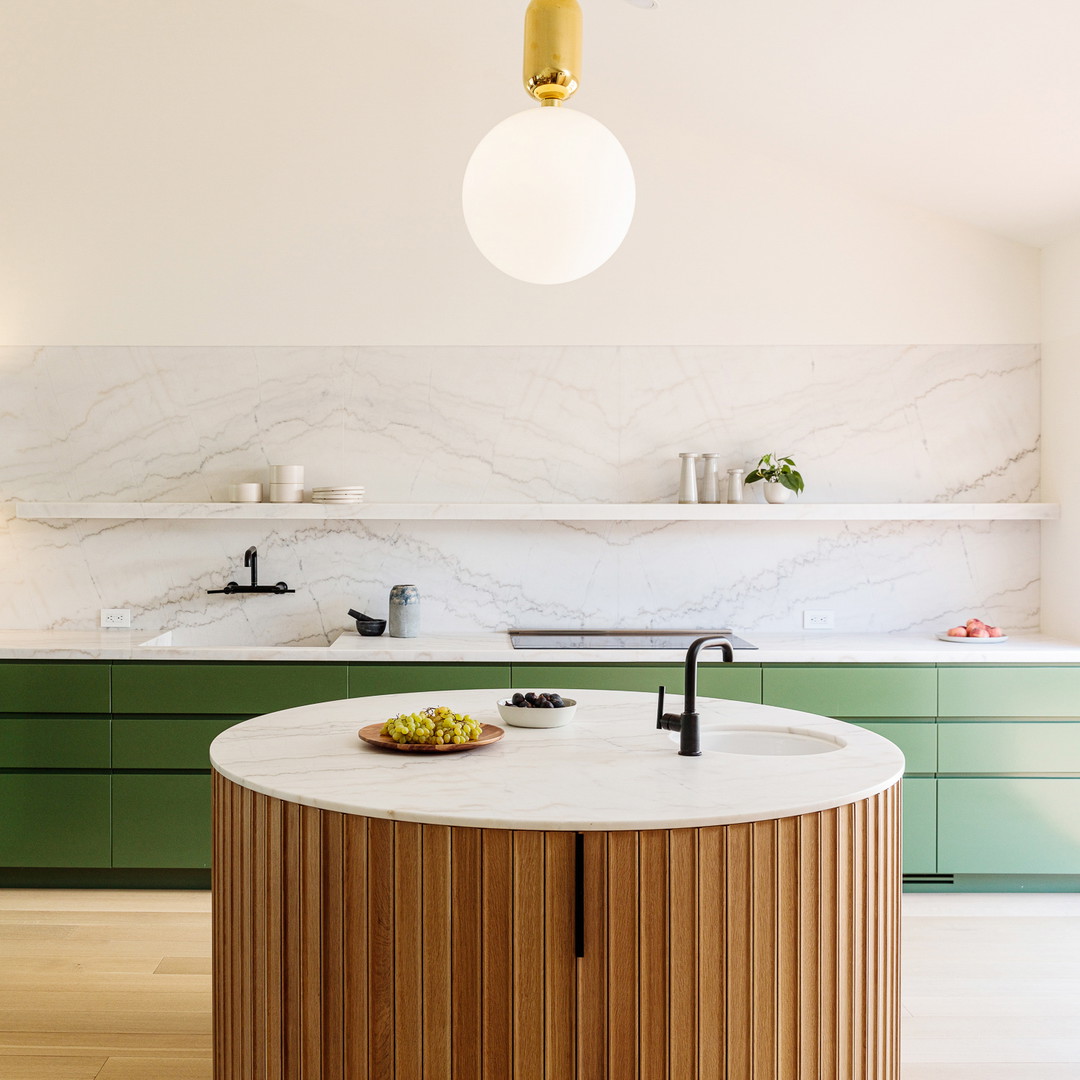 a kitchen with a marble counter top and green cabinets