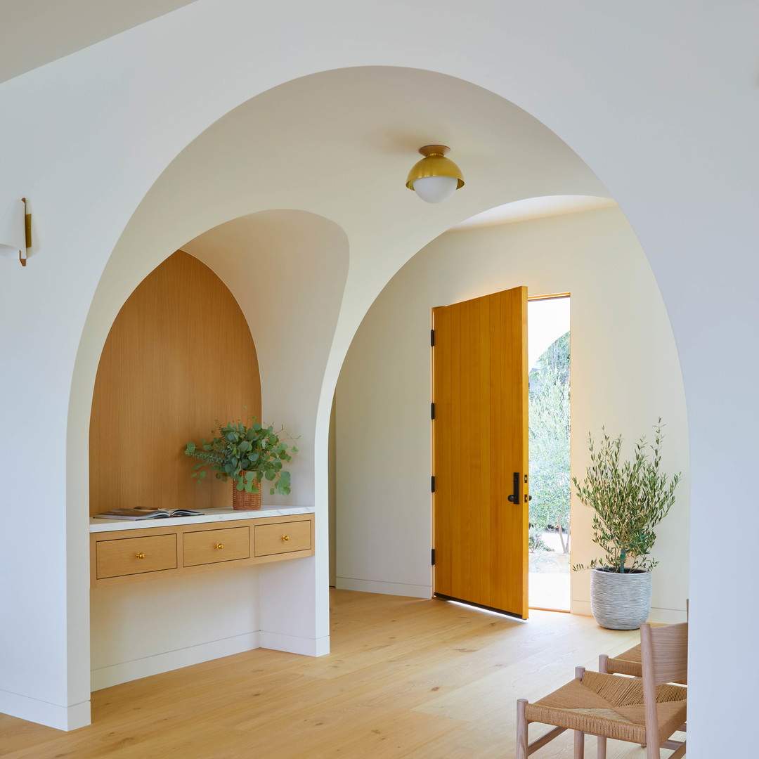 a room with a wooden door and a plant in a pot