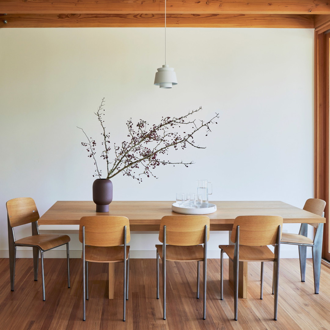 a dining room table with a vase of flowers on top of it