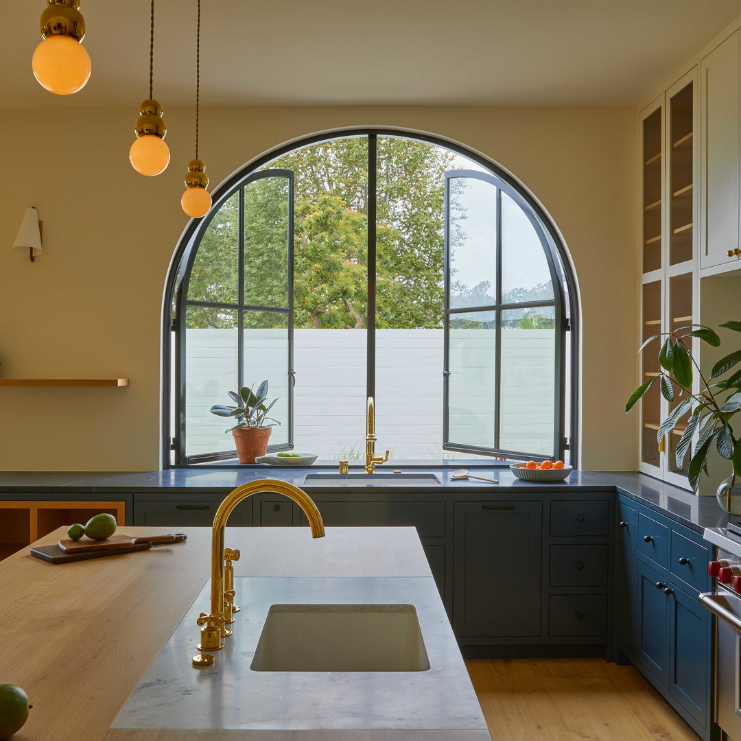 a kitchen with a large arched window and a sink