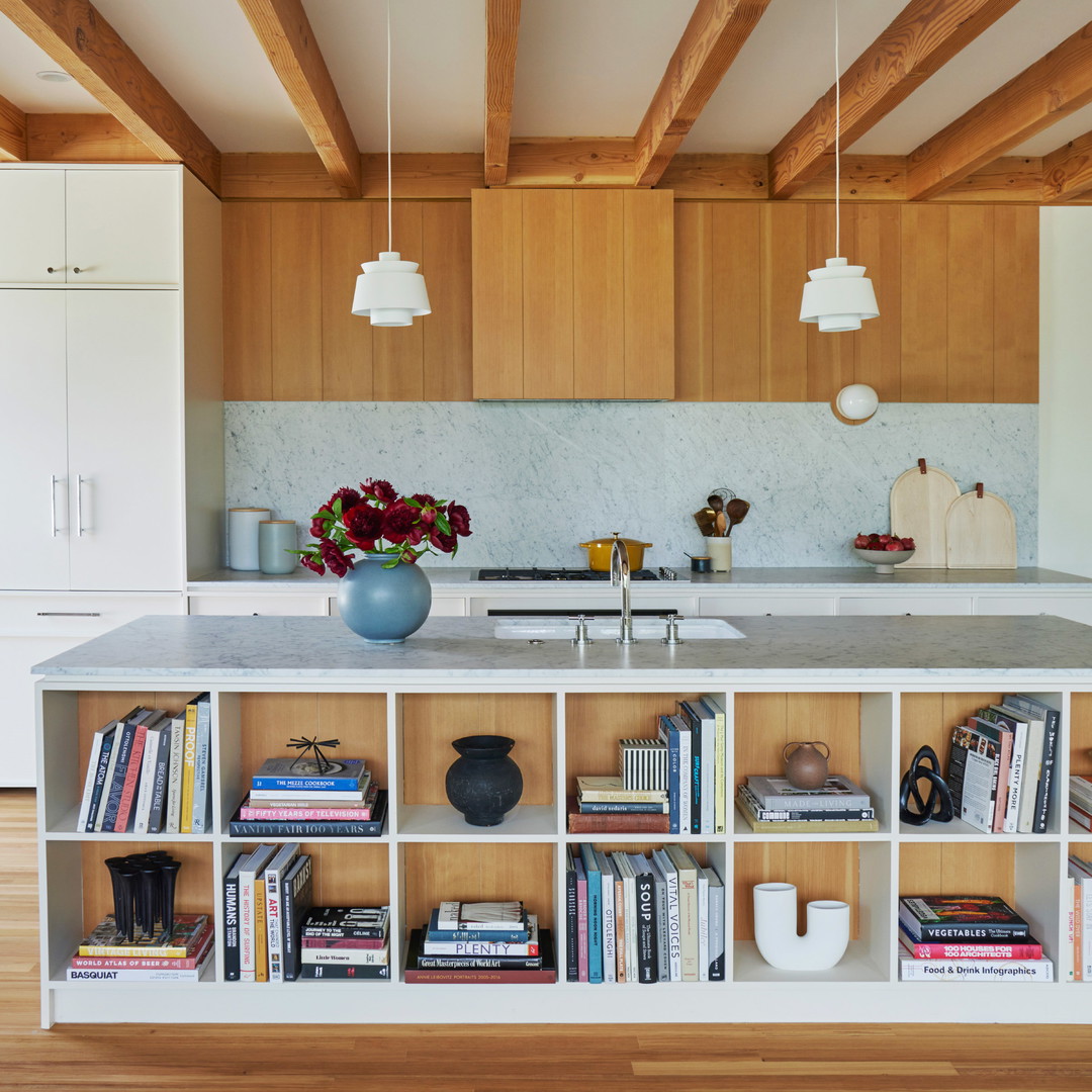 a kitchen with a center island surrounded by books