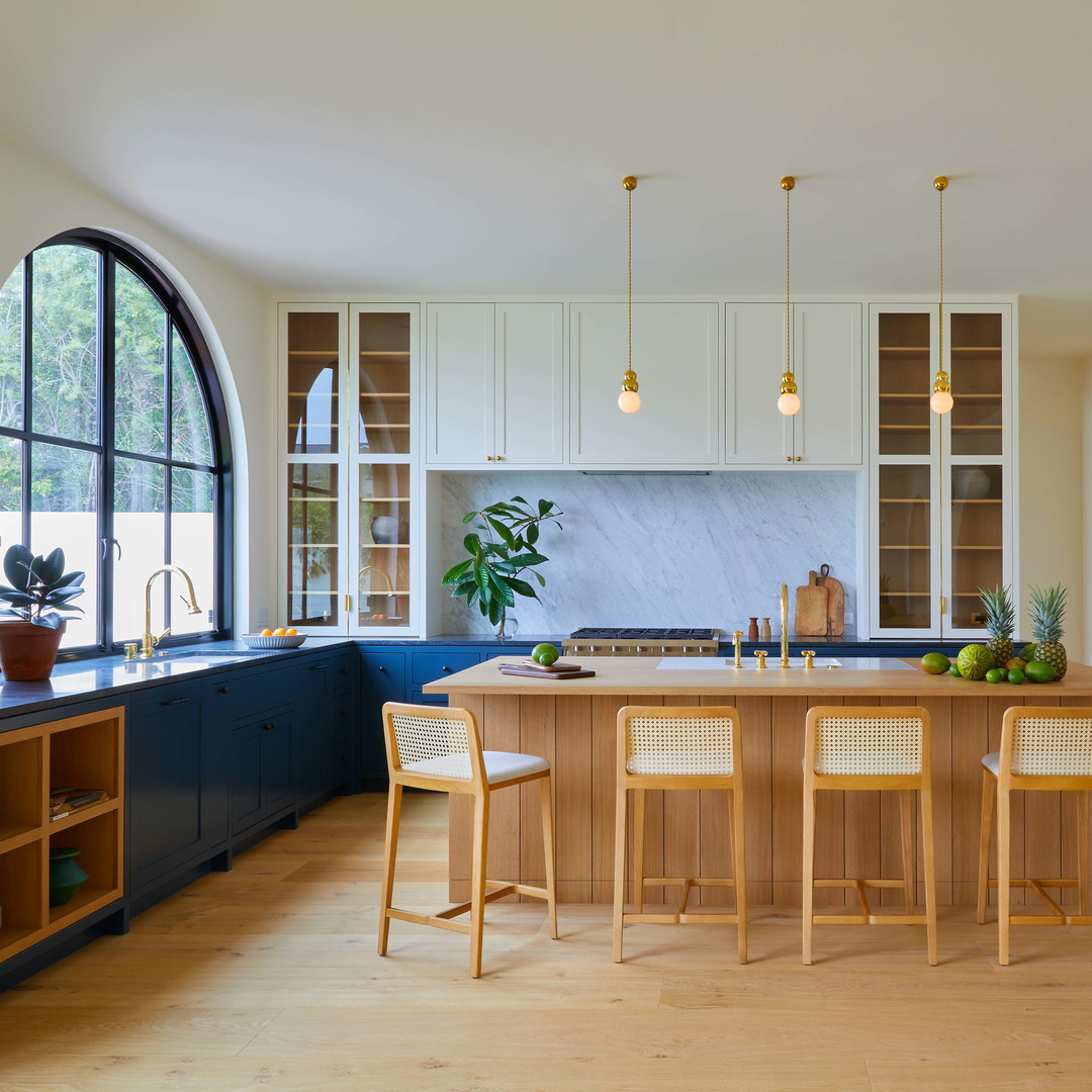 a large kitchen with a center island with chairs