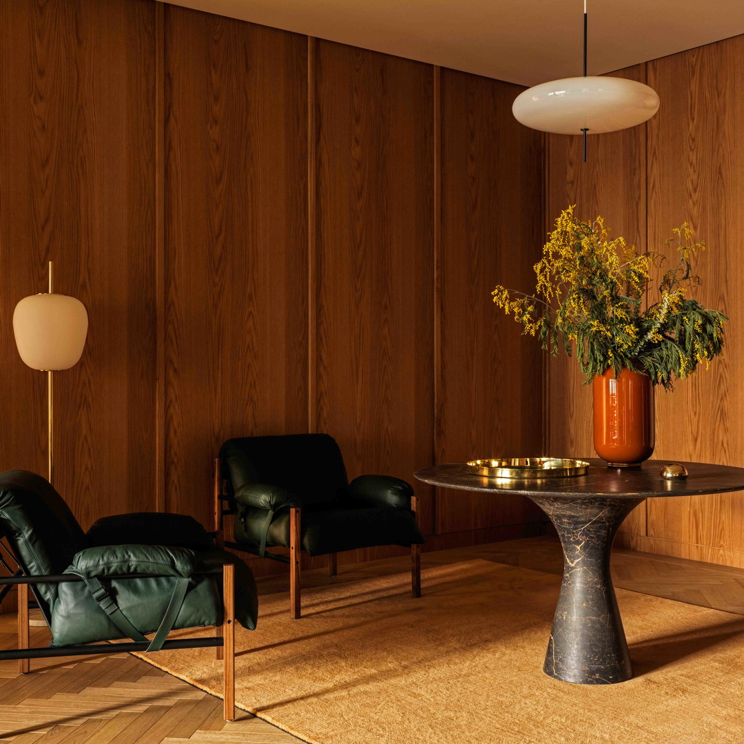 a chair and table in a room with wood paneling