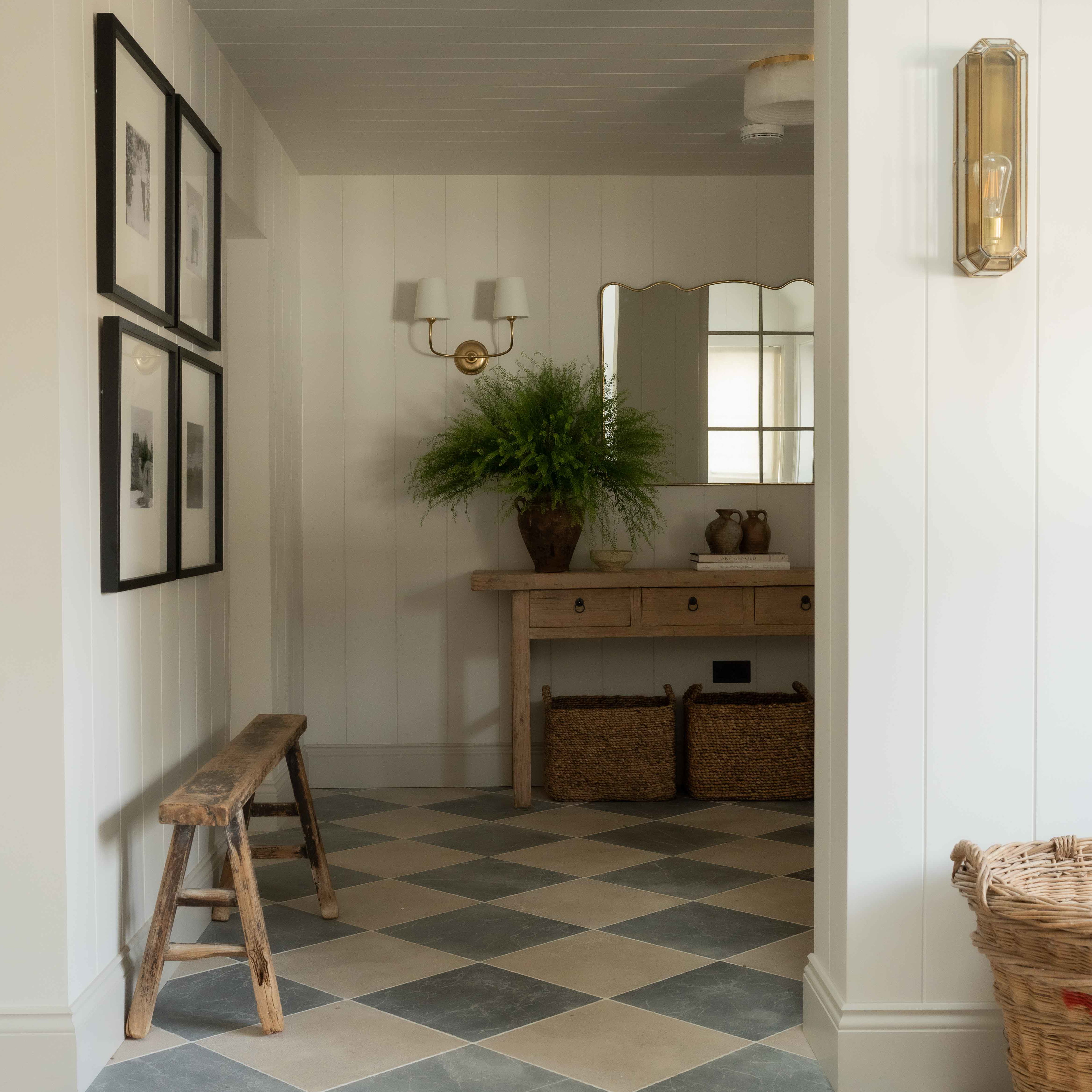 a hallway with a checkered floor and a wooden bench