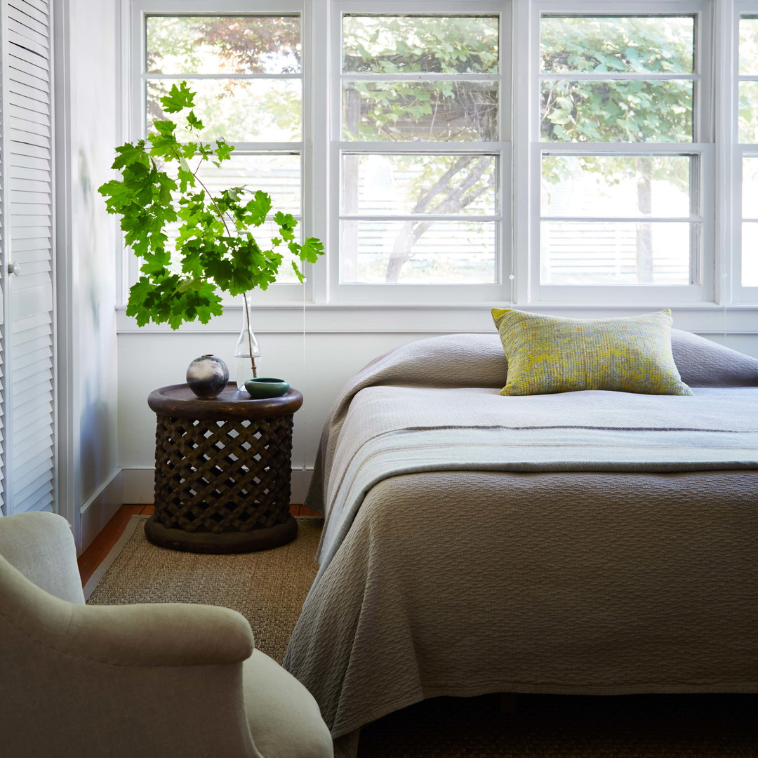 a bedroom with a bed, chair and window