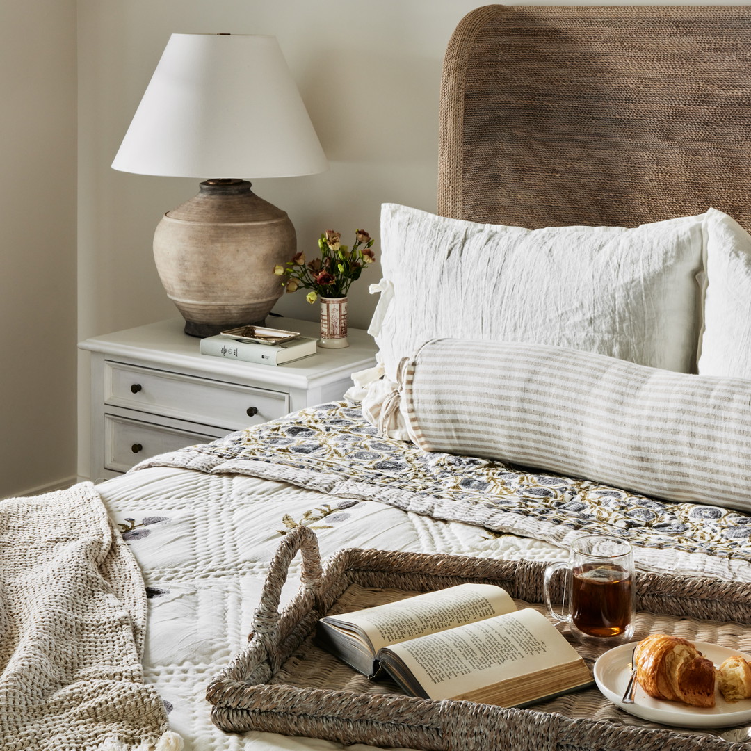 a tray of food and a book on a bed