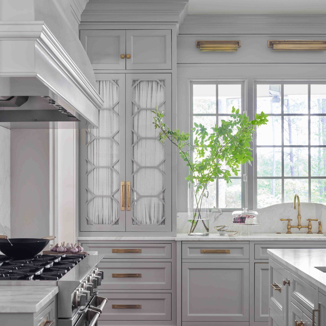 a kitchen with white cabinets and wood floors