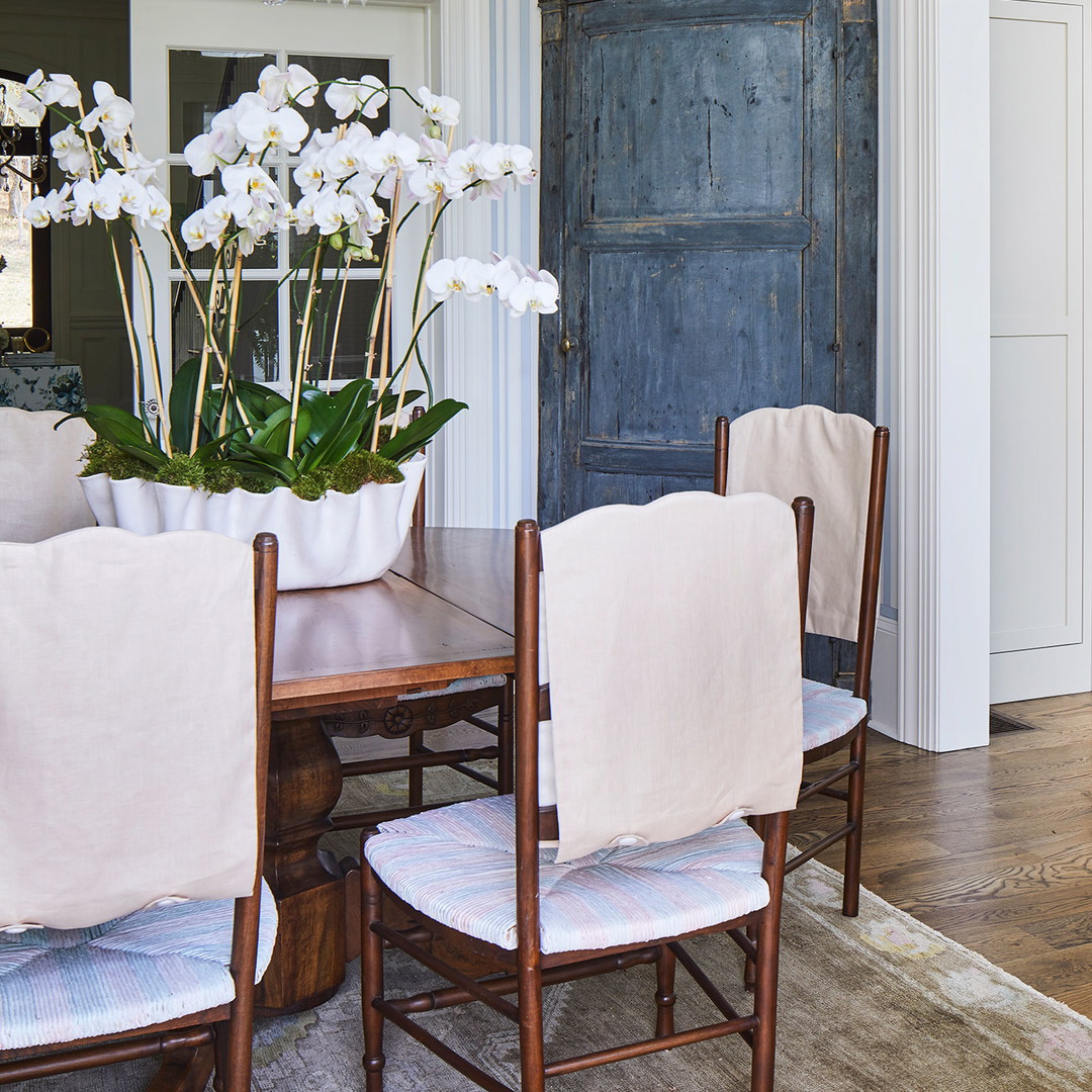 a dining room table with a vase of flowers on it