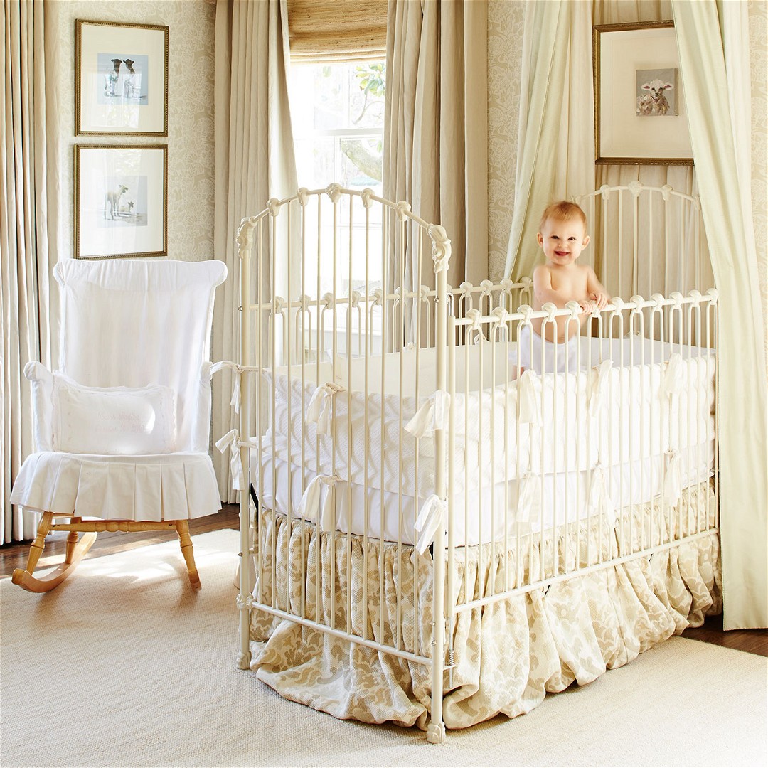 a baby in a crib in a room with a chandelier