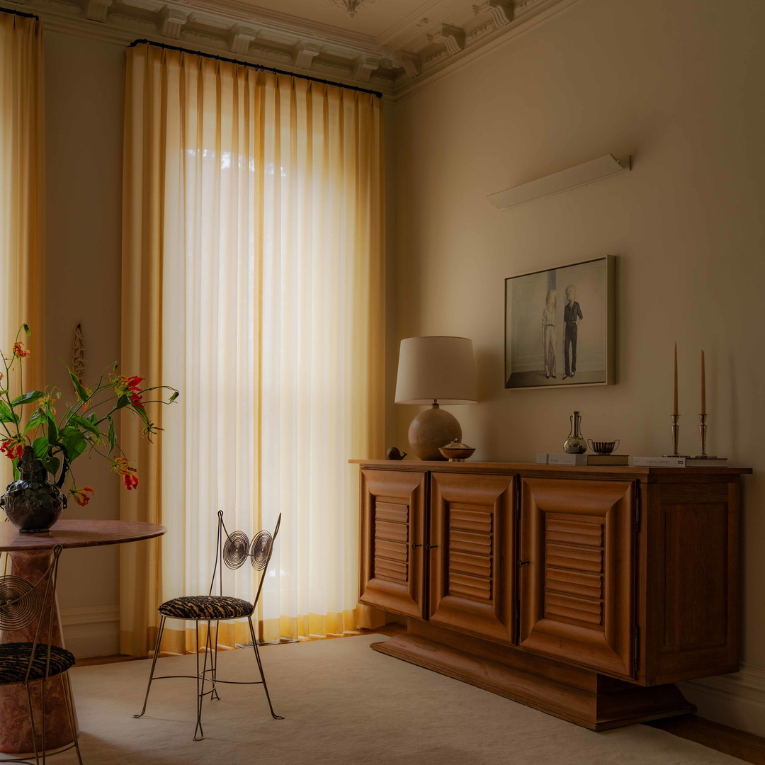 a living room with a table and a vase of flowers