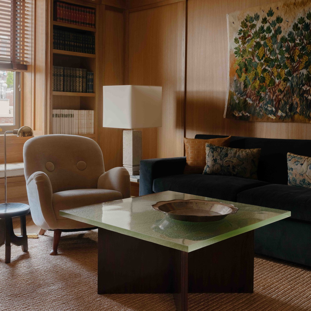 a living room filled with furniture and a painting on the wall