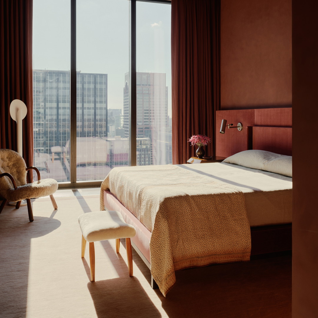 a bedroom with a large window overlooking a city