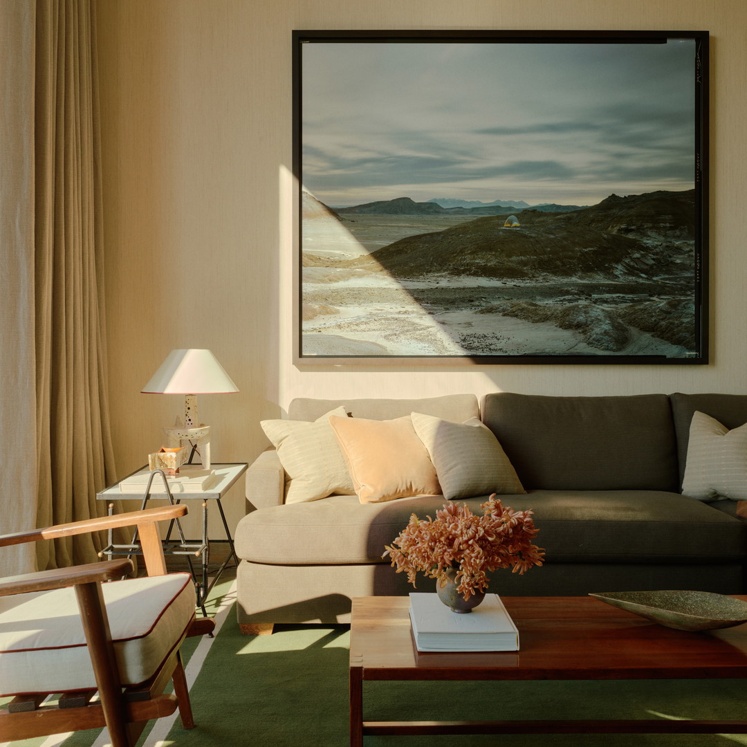 a living room filled with furniture and a painting on the wall