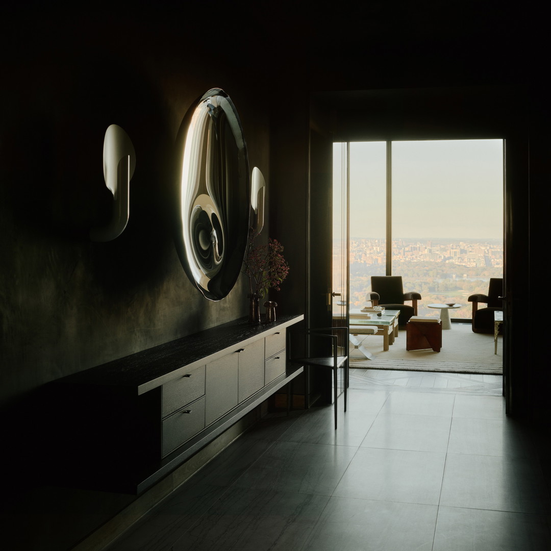 a living room with a large mirror and a view of the city