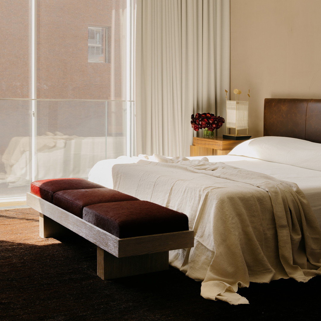 a bed sitting in a bedroom next to a window