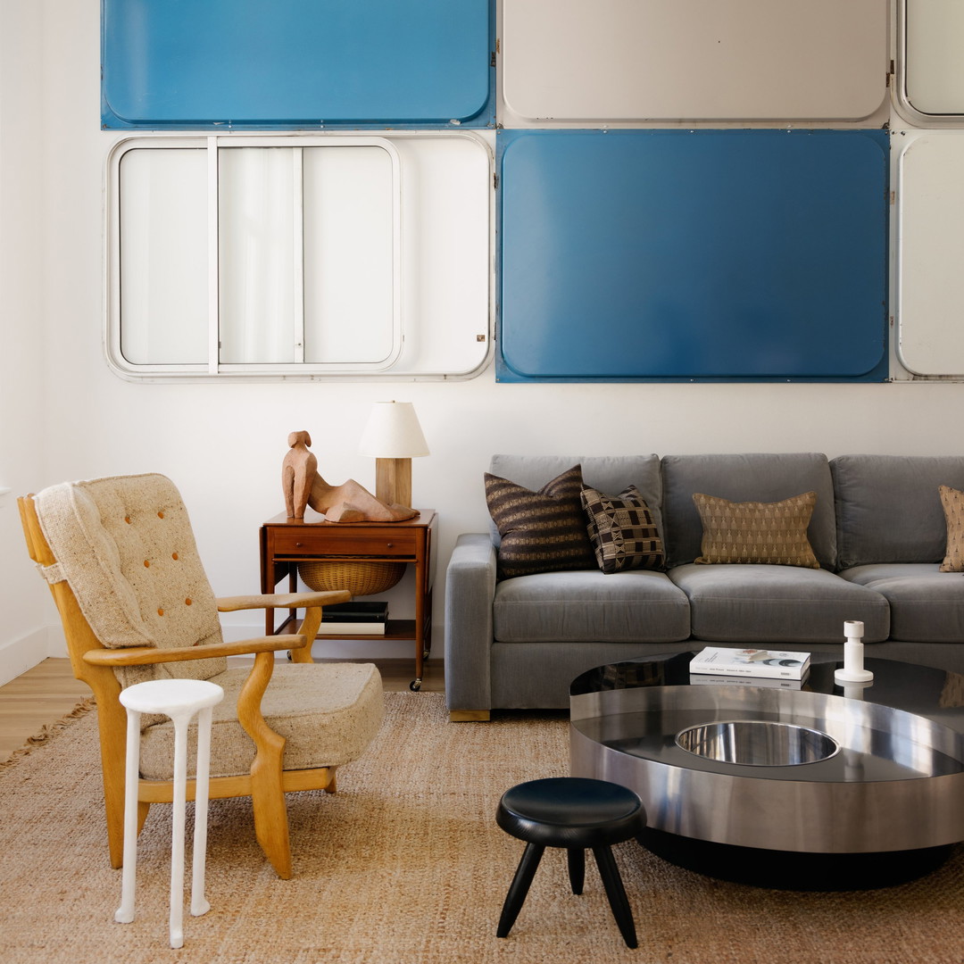 a living room filled with furniture and a large mirror