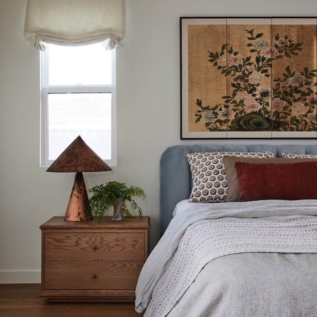 a bedroom with a bed and a painting on the wall