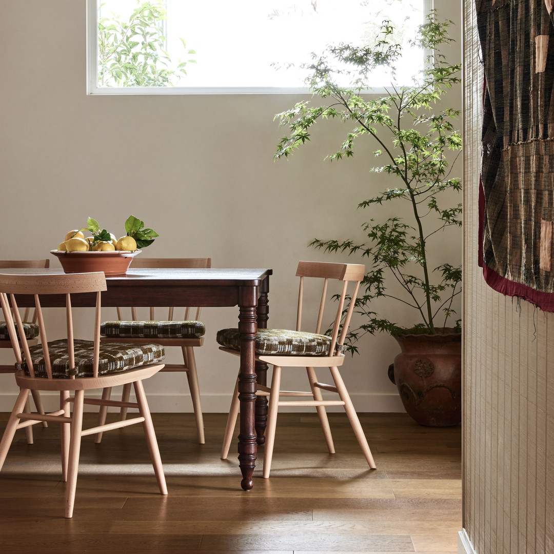 a dining room table with a bowl of fruit on top of it