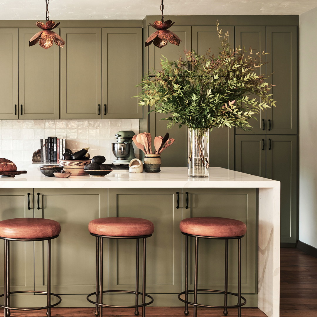 a kitchen with three stools and a center island