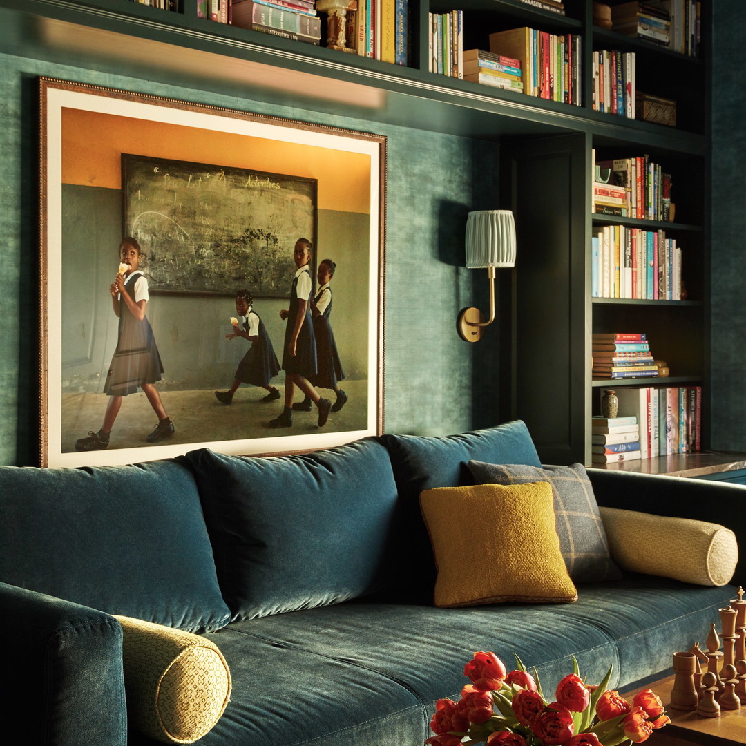 a living room filled with furniture and a painting on the wall